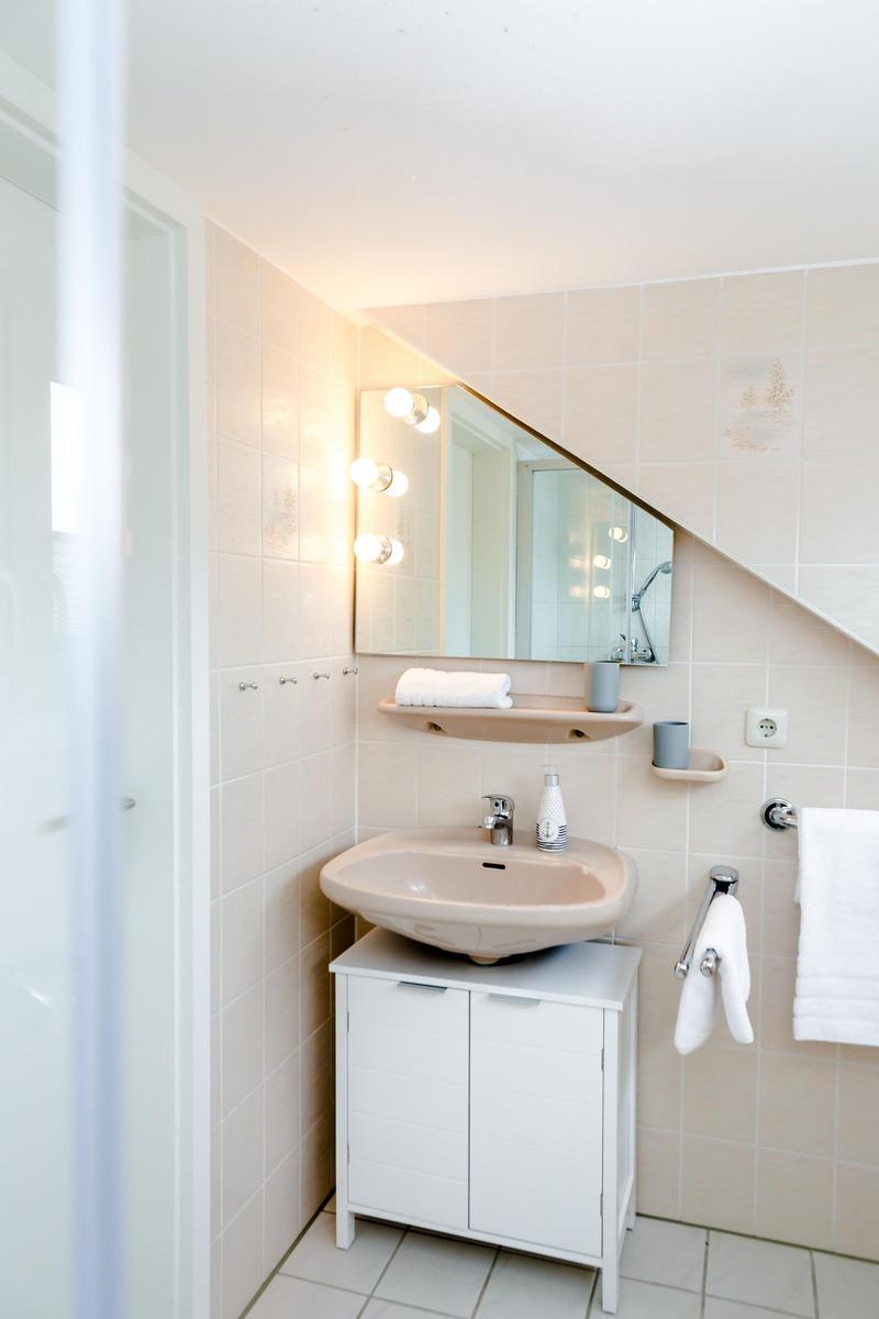 Bathroom with sink, mirror, and shower area