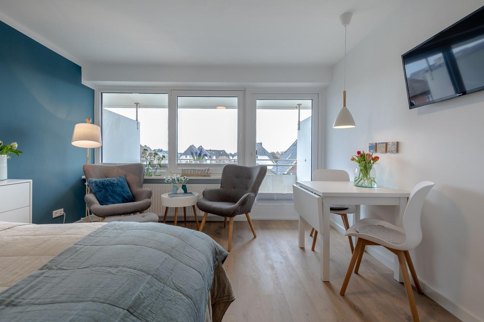 Schlafzimmer mit Blick auf Balkon, Esstisch und TV