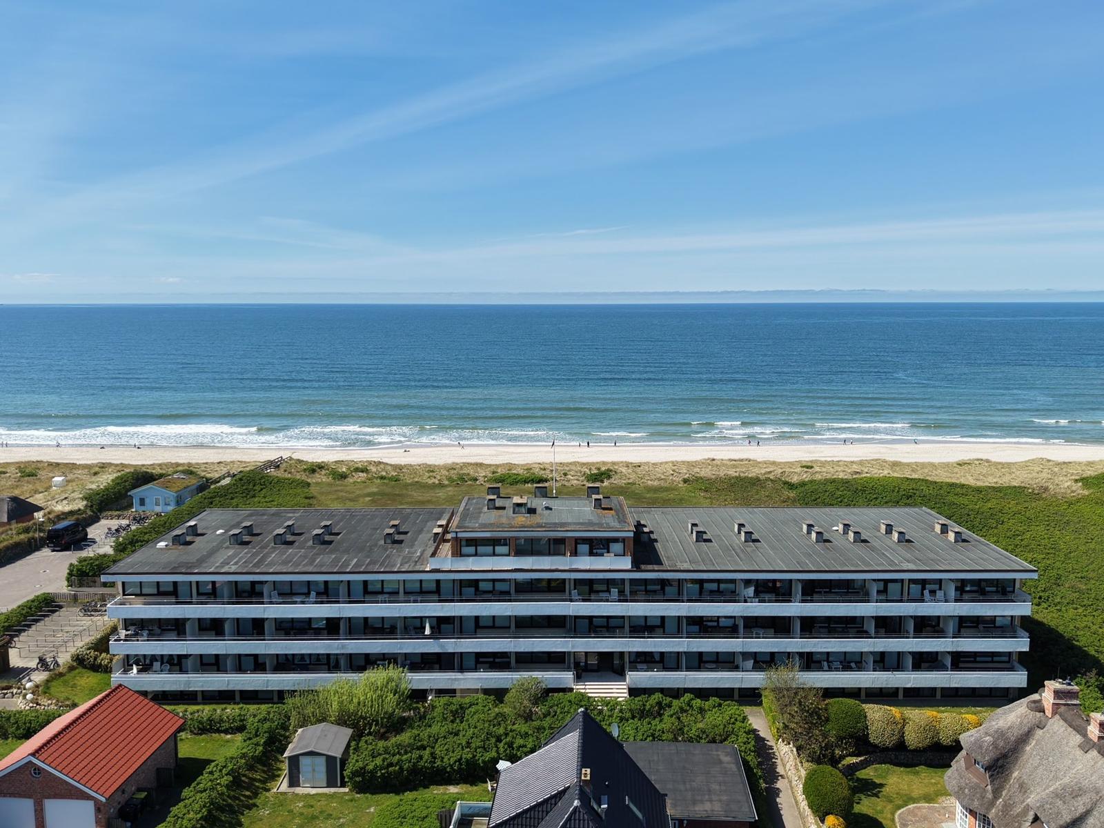Modernes Mehrfamilienhaus mit Meerblick und Strand direkt daneben.