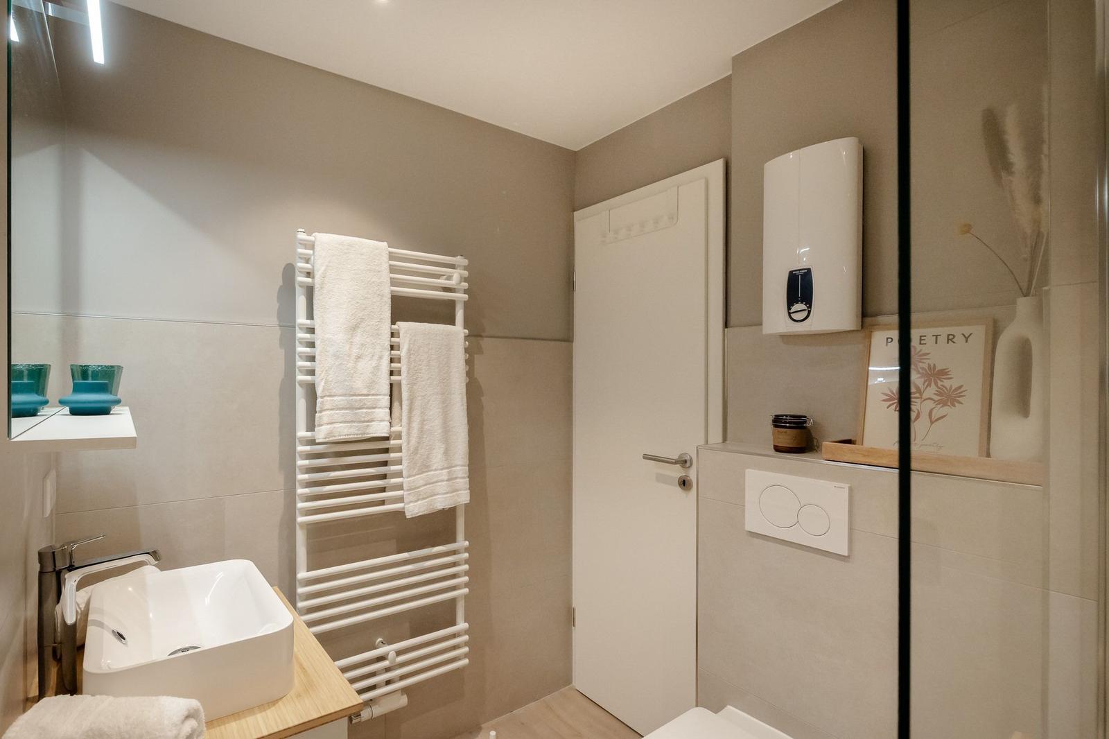 Badezimmer mit Waschbecken, Handtuchhalter und Toilette