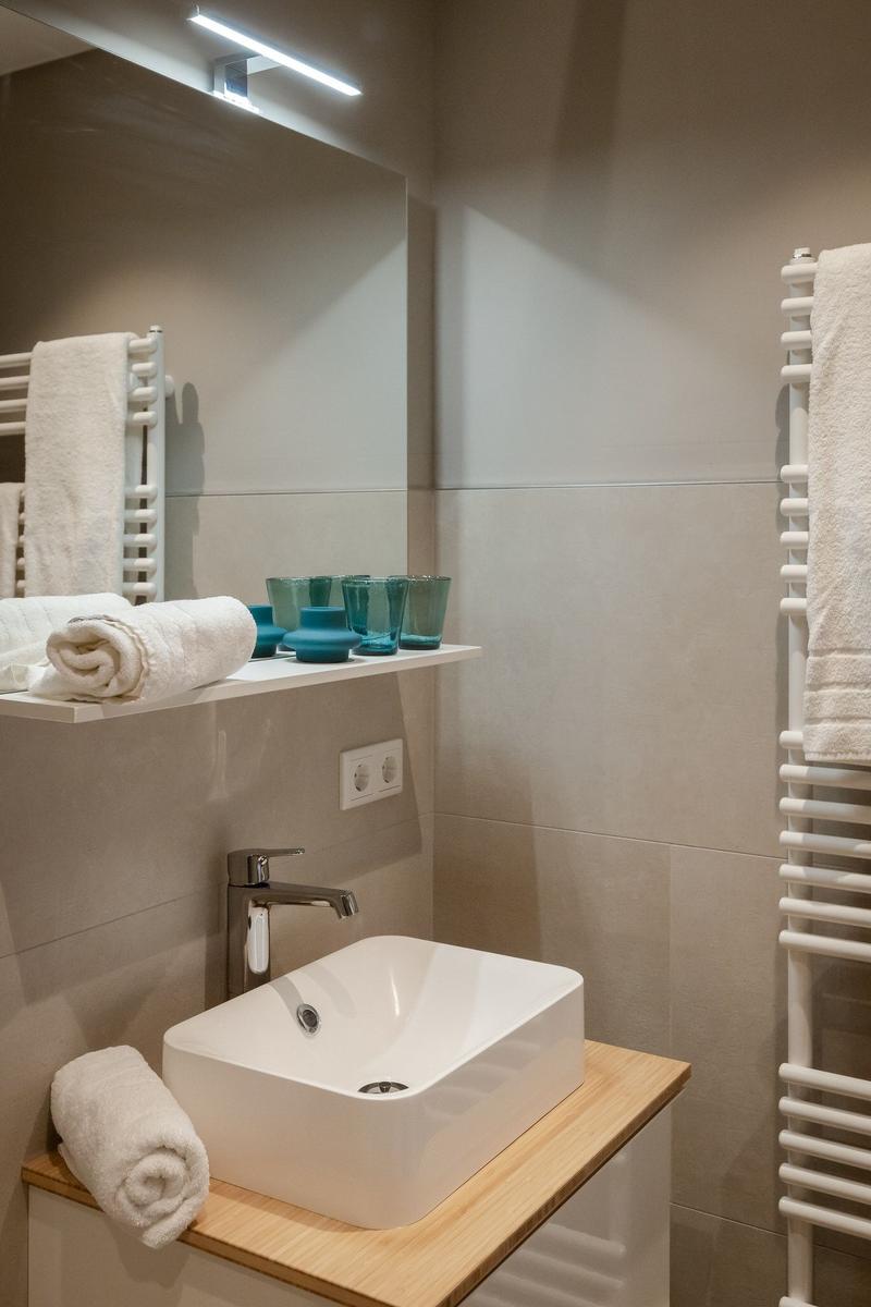 Badezimmer mit Waschbecken, Spiegel und Handtuchhalter