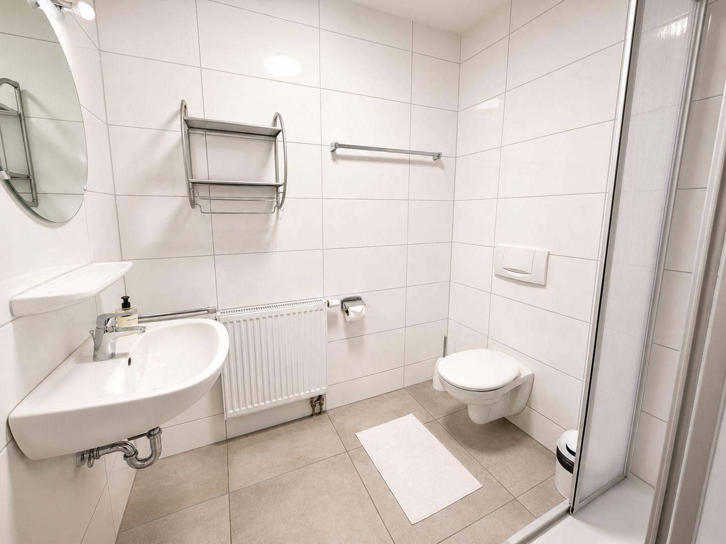 Badezimmer mit Dusche, Toilette und Waschbecken.