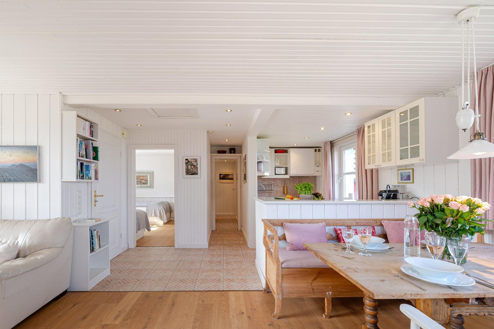 Wohnbereich mit Essbereich, Küche und Schlafzimmer im Hintergrund.