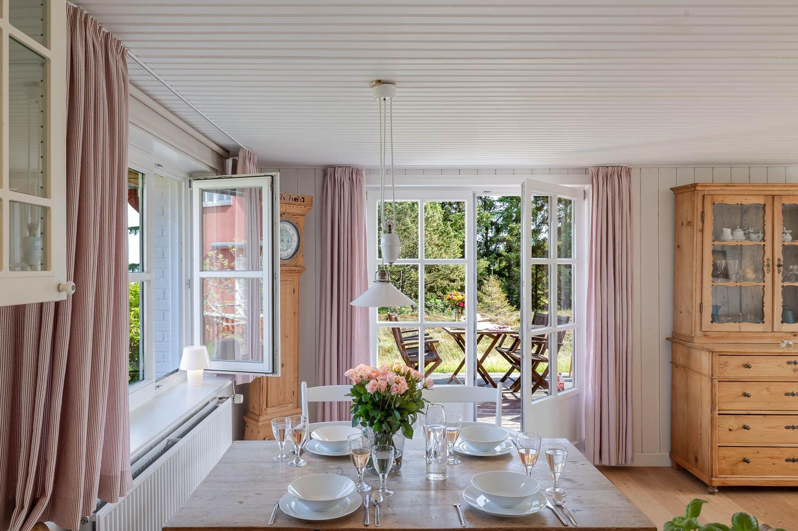 Esszimmer mit Tisch, Stühlen und Blick auf die Terrasse.