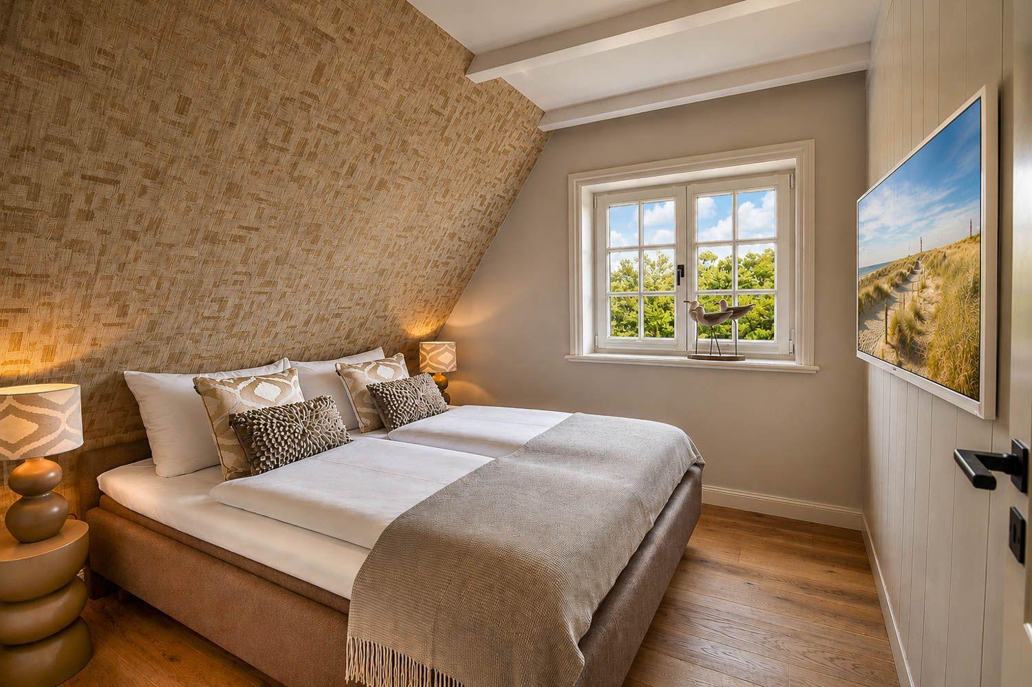 Schlafzimmer mit Doppelbett, Holzboden und Fenster mit Blick auf Bäume.
