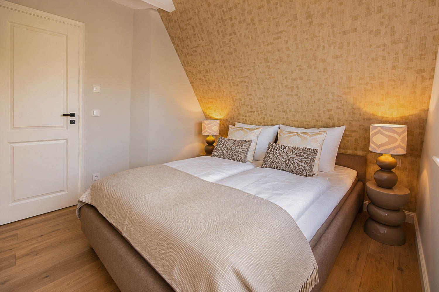 Schlafzimmer mit Doppelbett, Holzboden und gemusterter Wand