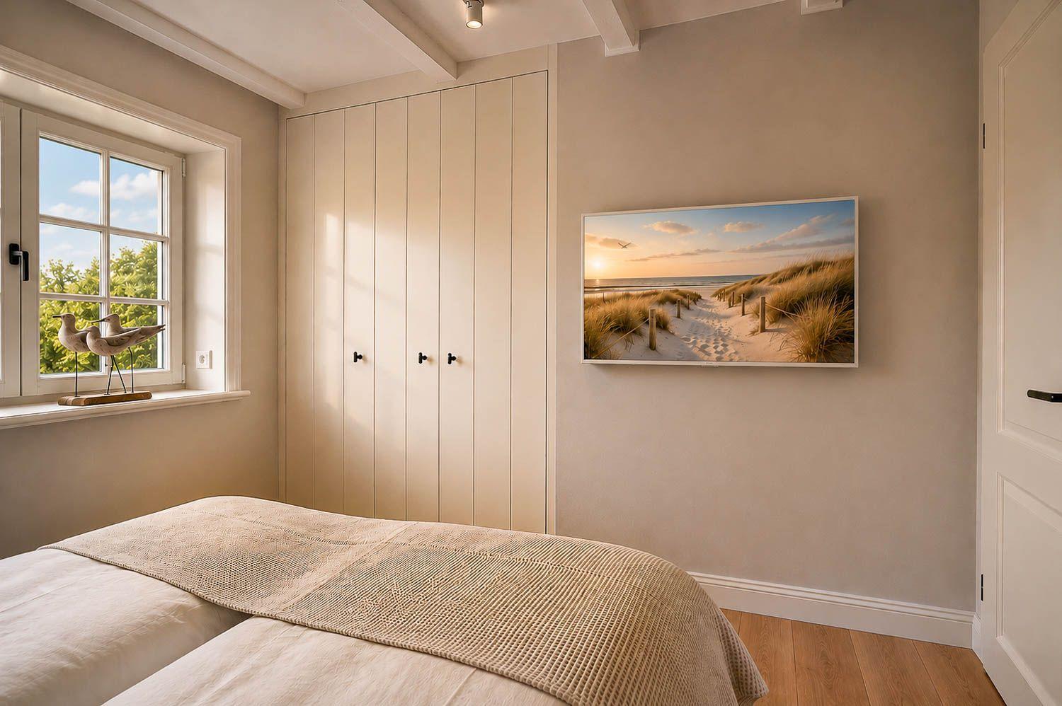 Schlafzimmer mit Bett, Kleiderschrank, Fenster und Wandbild mit Strandmotiv.
