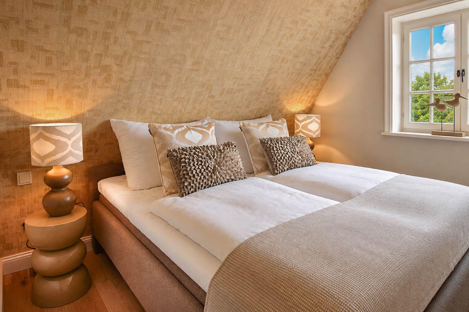 Schlafzimmer mit Doppelbett, zwei Nachttischen und Fenster mit Blick auf Bäume.