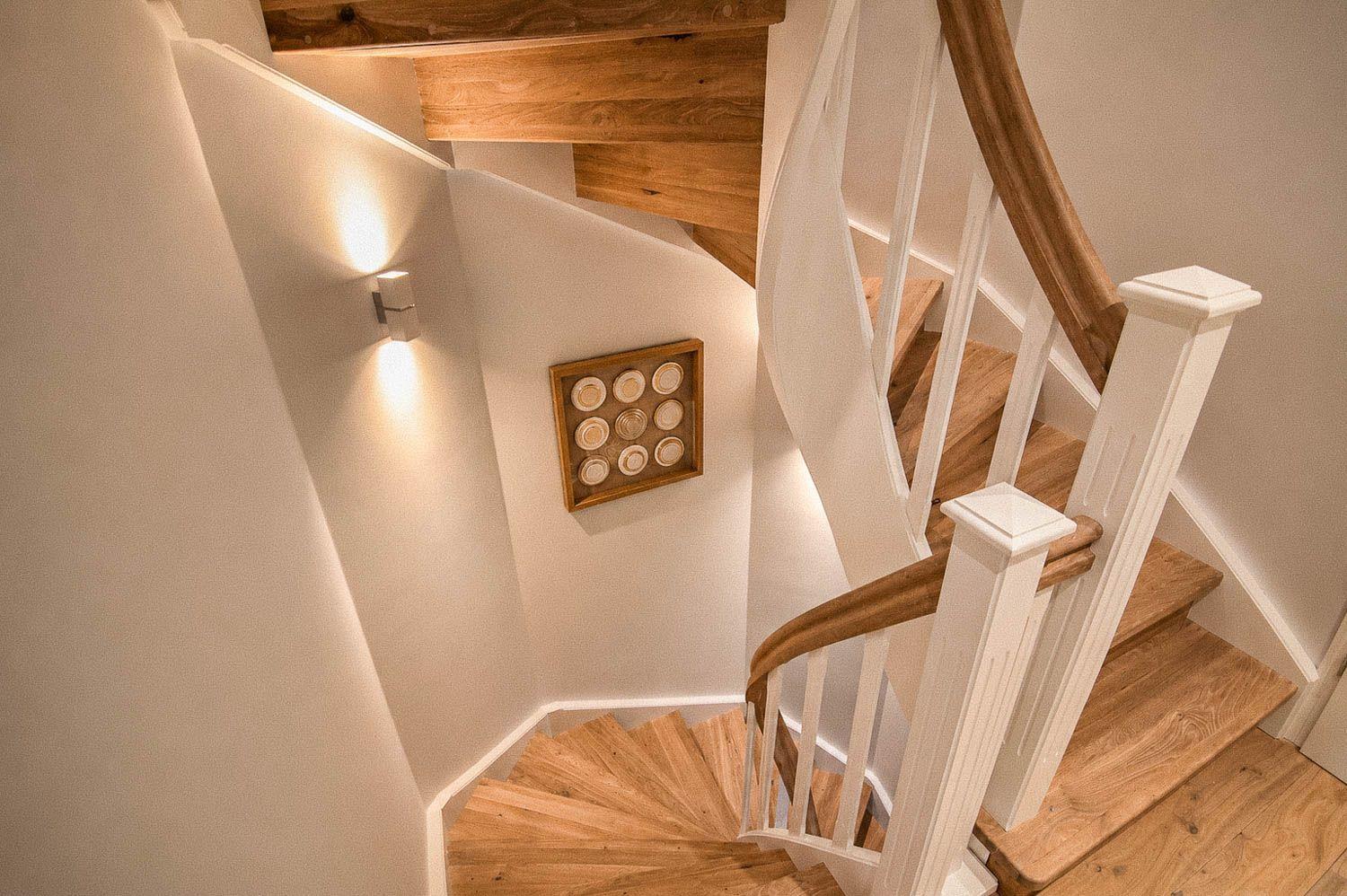 Hölzerner Wendeltreppe mit weißem Geländer und Wandbeleuchtung