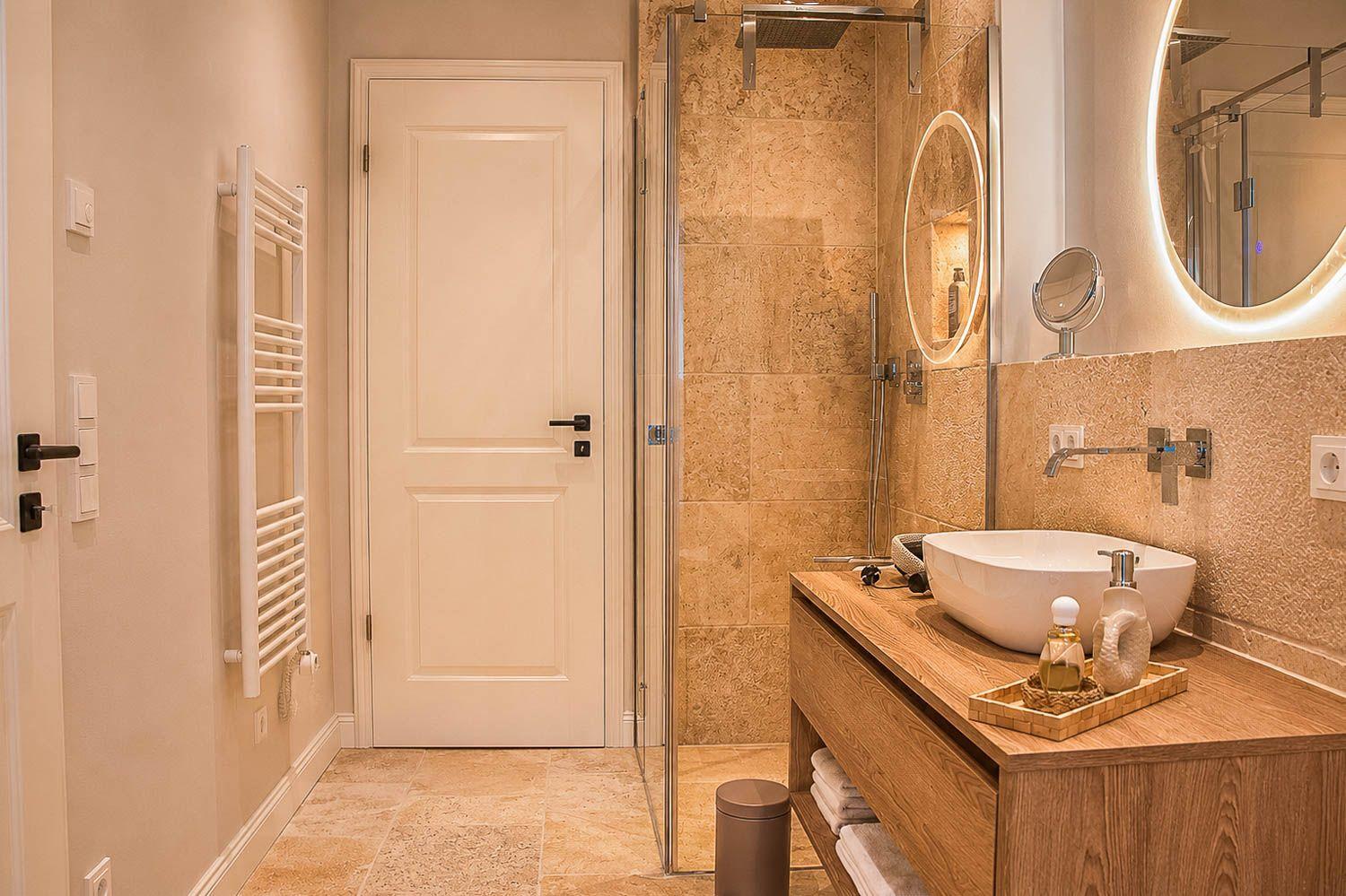 Badezimmer mit Dusche, Waschbecken und Heizkörper