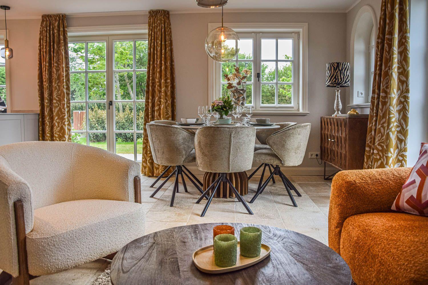 Esszimmer mit Tisch, Stühlen und Blick auf Garten. Wohnbereich mit Sitzgelegenheiten.