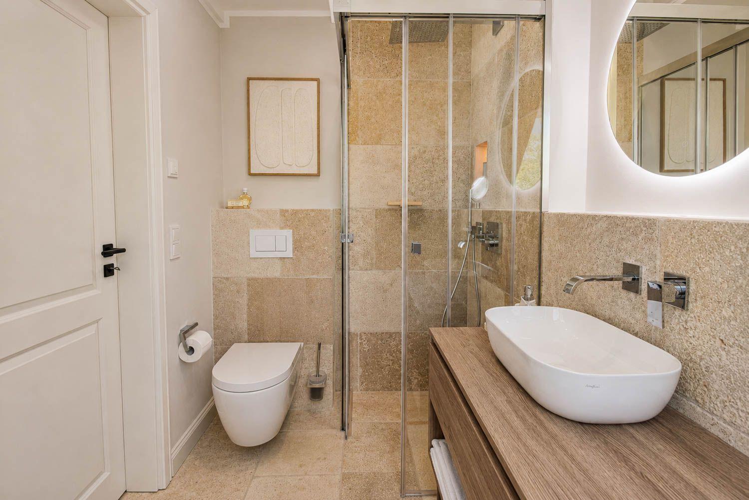 Badezimmer mit Dusche, Waschbecken und Toilette
