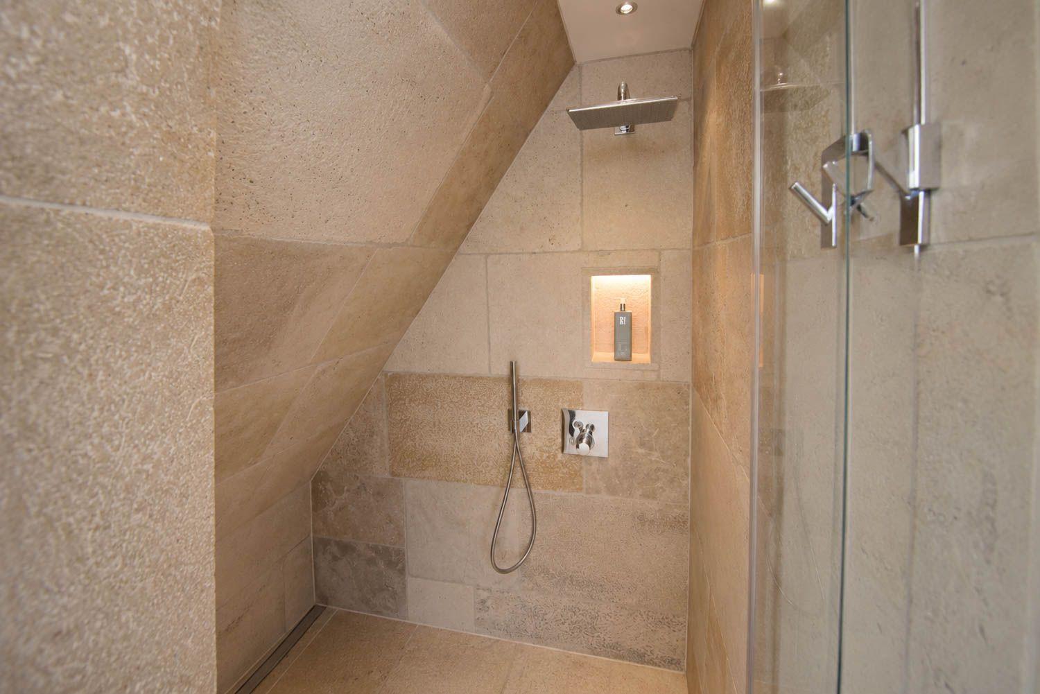 Dusche mit Glaswand, Duschbrause und Handbrause an Steinwand