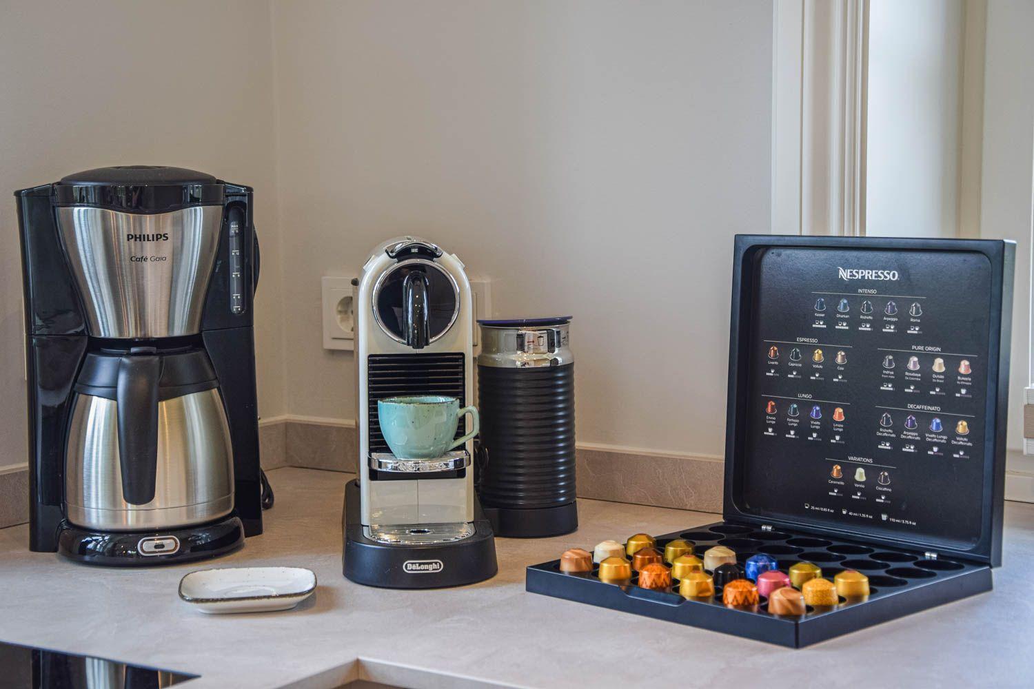 Kaffeebereiter und Nespresso-Kapseln auf Küchenarbeitsplatte