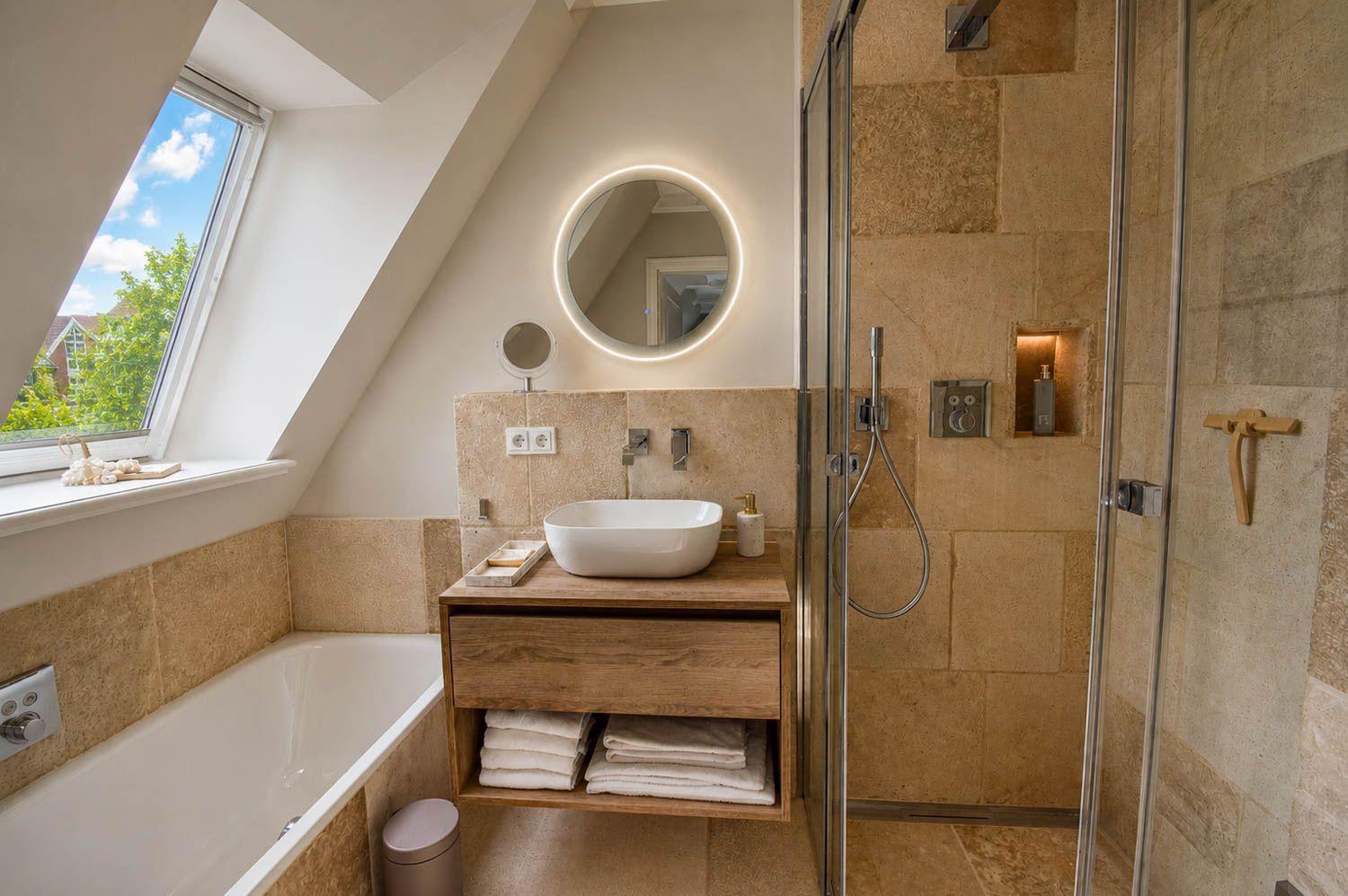Badezimmer mit Dusche, Badewanne und Waschtisch unter Dachschrägen