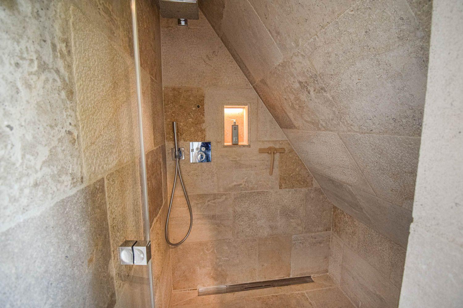 Dusche mit Steinwand und Duschbrause