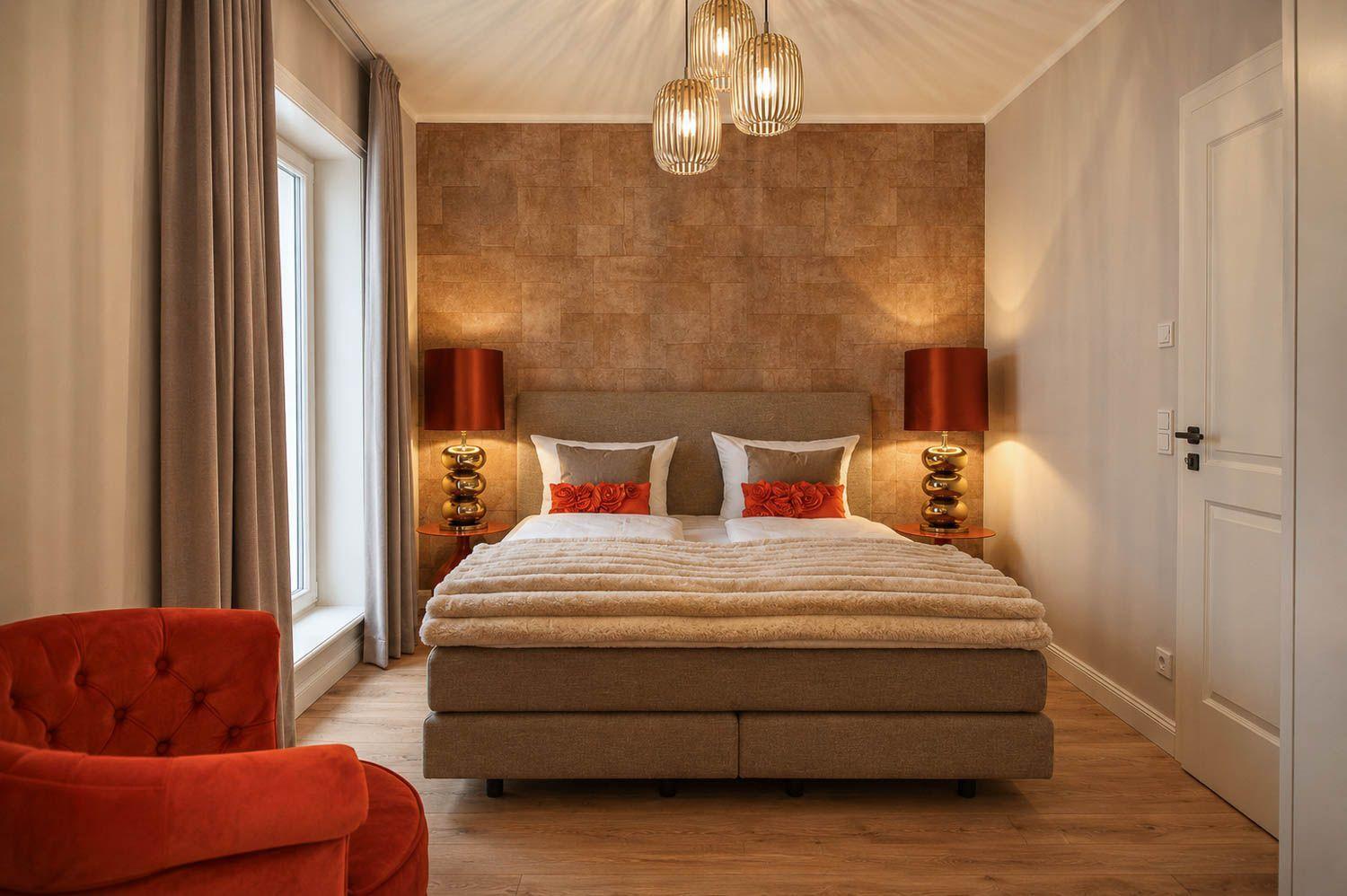 Schlafzimmer mit Bett, zwei Nachttischen, rotem Sessel und Deckenleuchte.