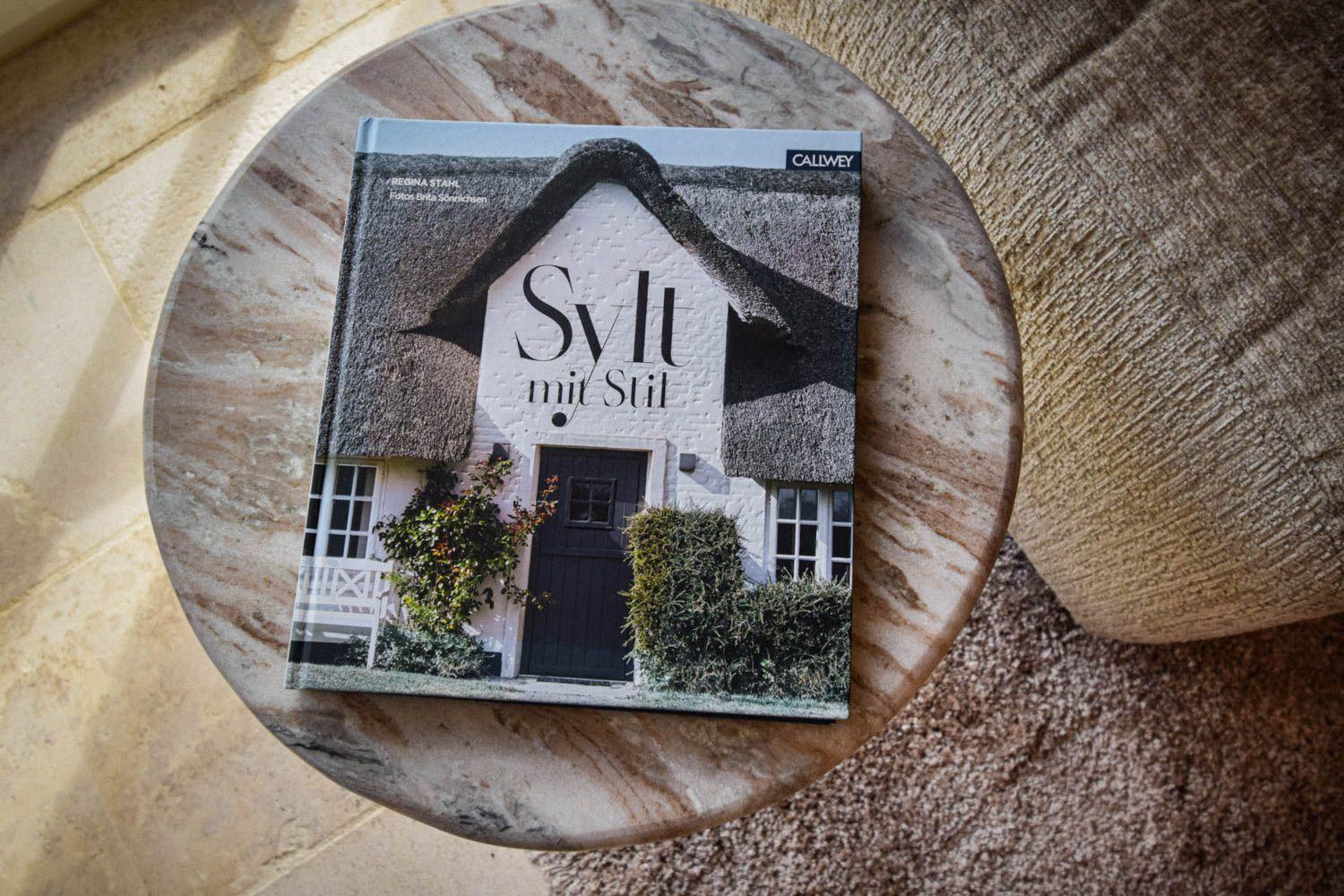 Buch Sylt mit Stil liegt auf runder Marmorplatte.