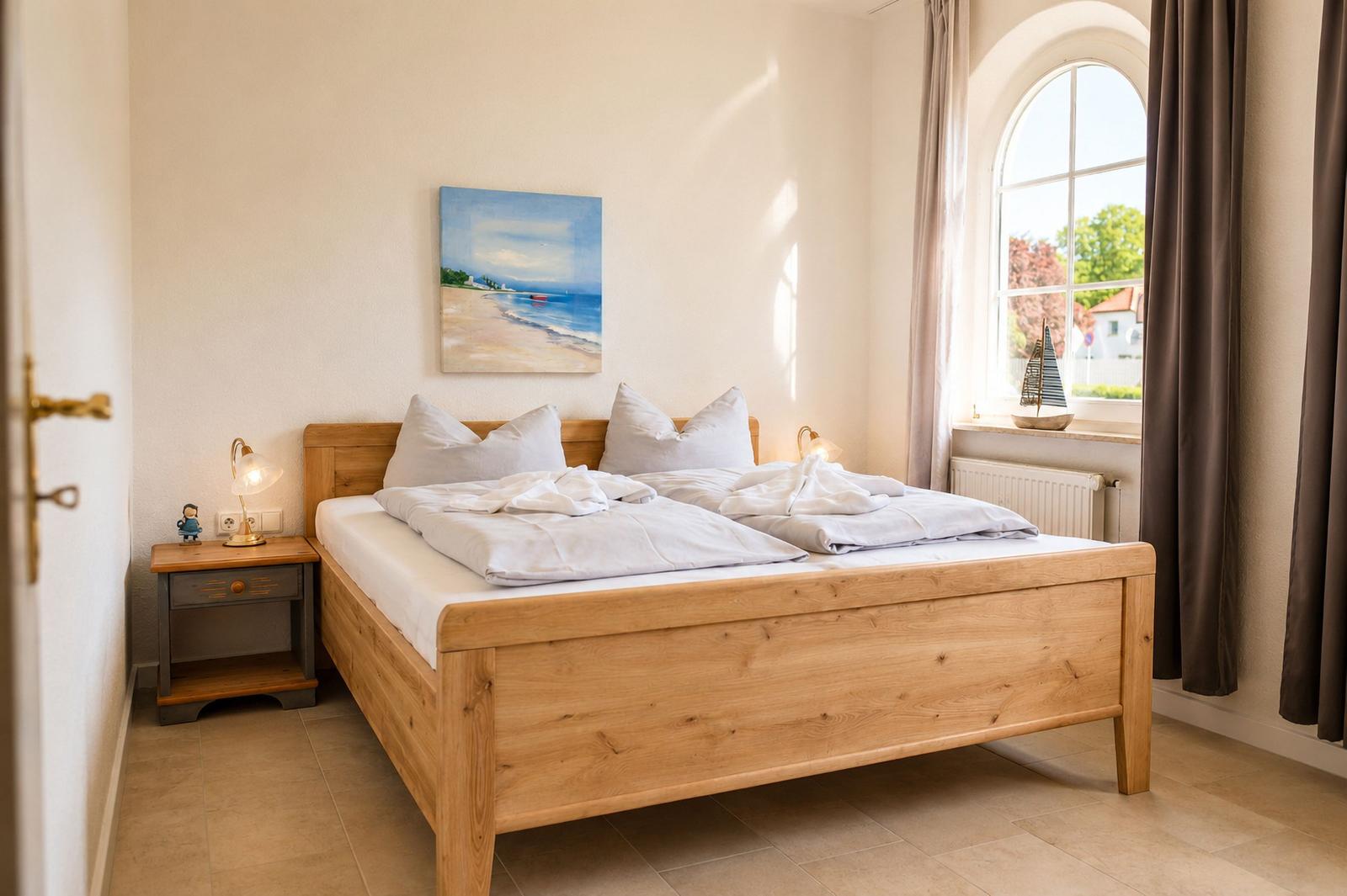 Ein Schlafzimmer mit einem Holzbett, einem Nachttisch und einem Fenster.