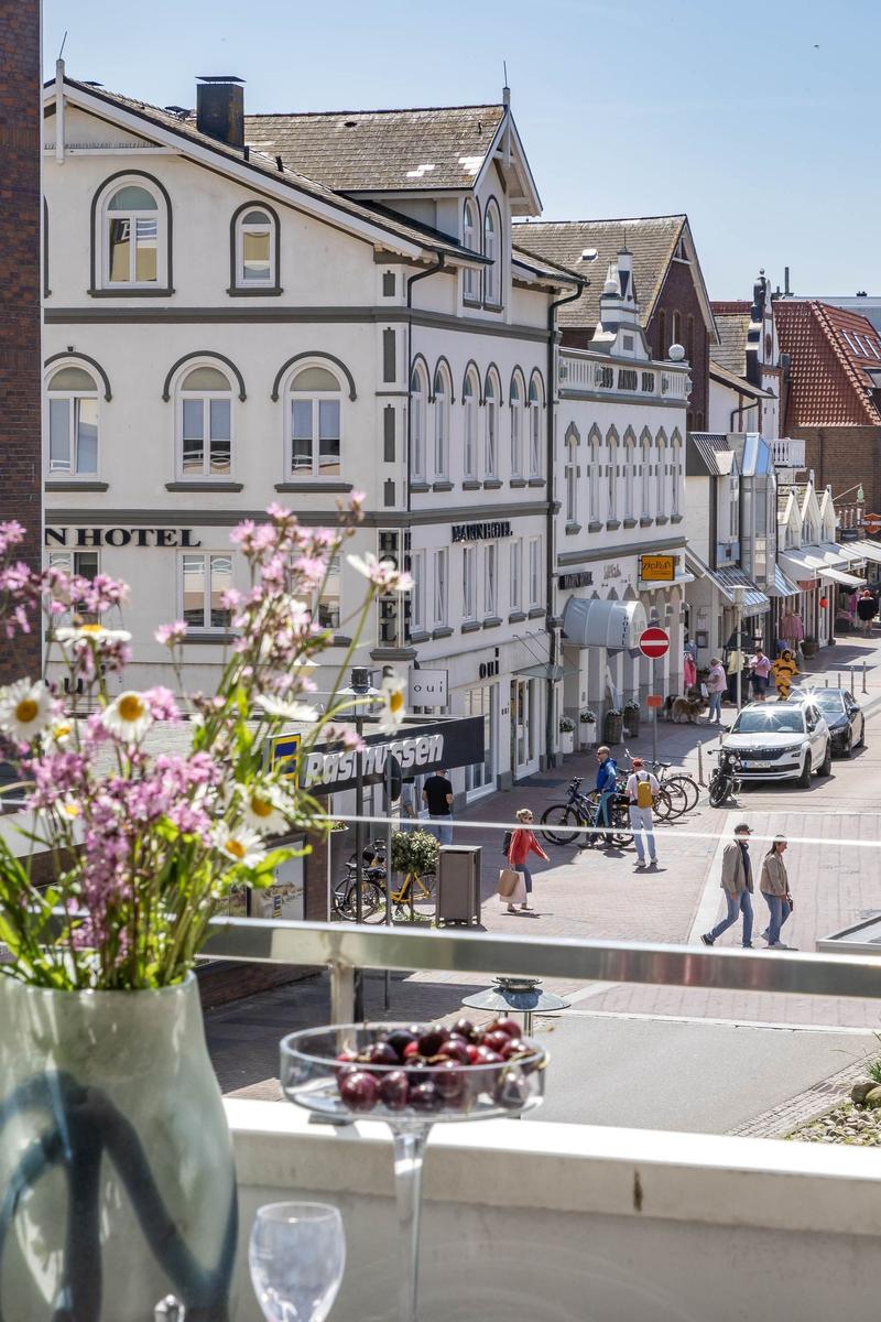 Balkon mit Blumen und Beeren über einen belebten Straßenmarkt in einer Stadt