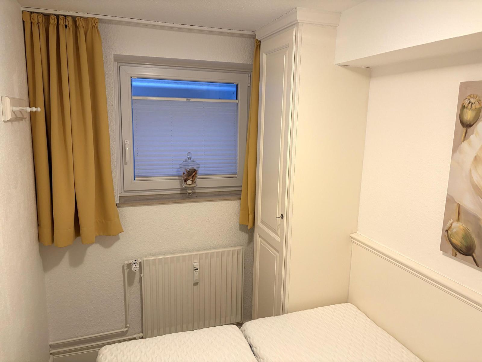 Schlafzimmer mit Fenster, Gardinen und Bett