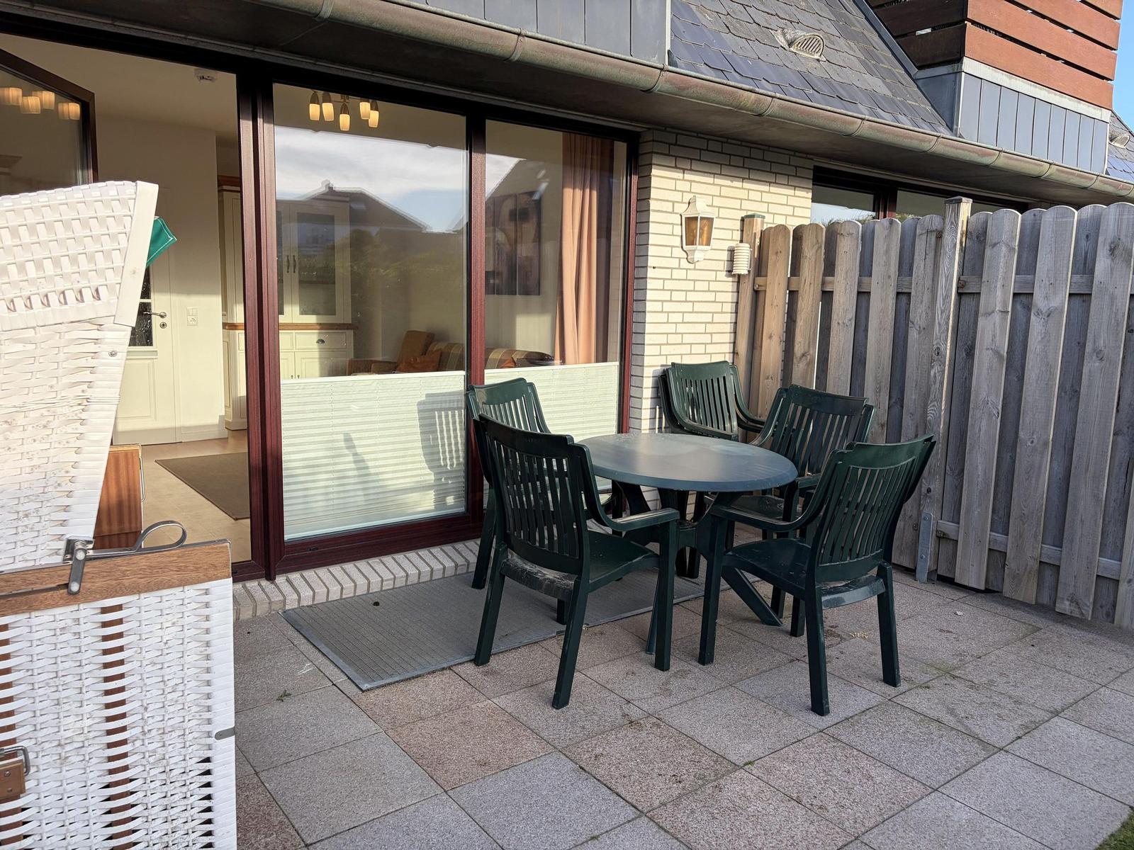 Terrasse mit Tisch und Stühlen, Durchgang zur Wohnung.