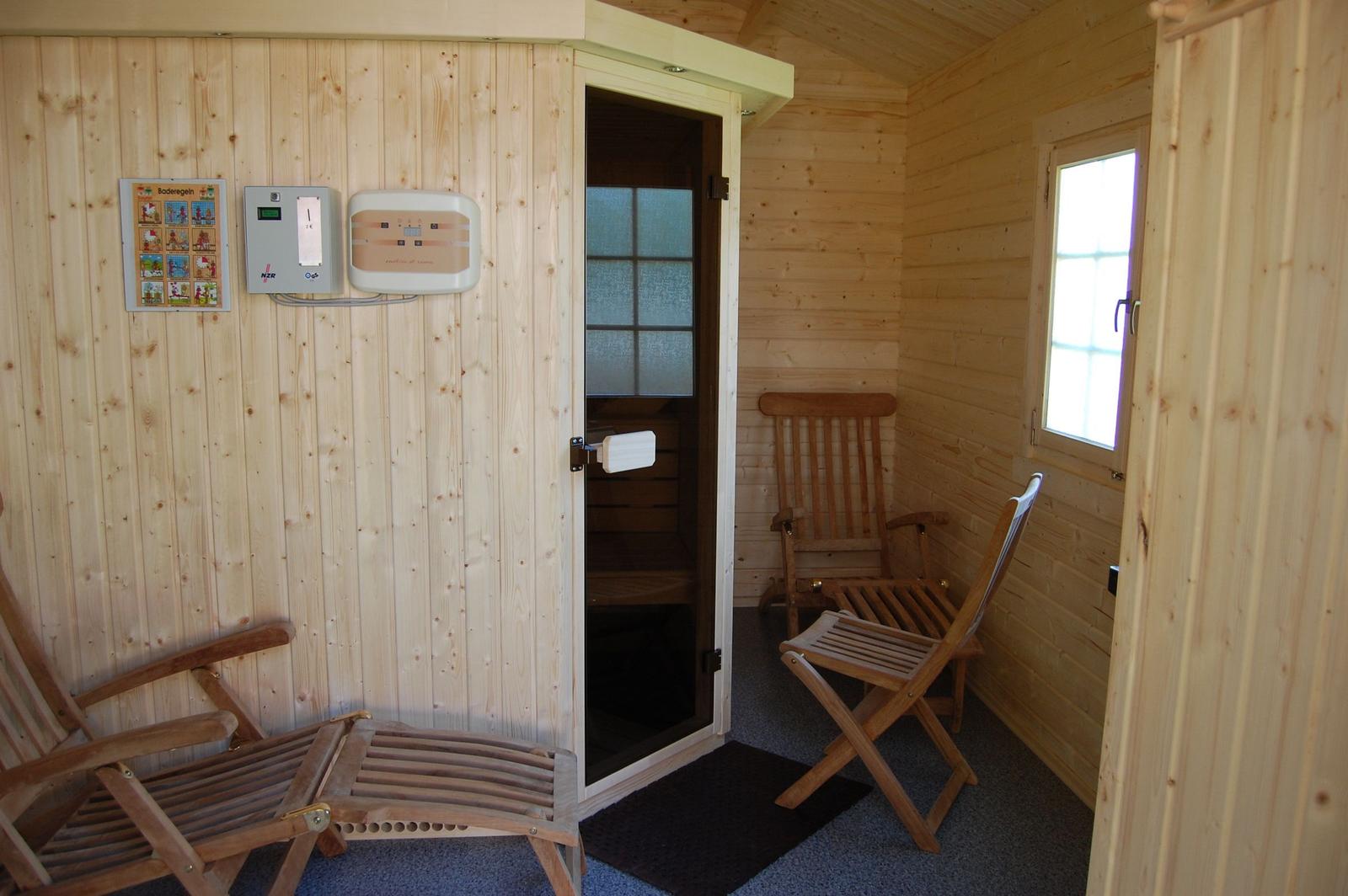 Sauna mit Holzwand, Sitzgelegenheiten und Fenster.