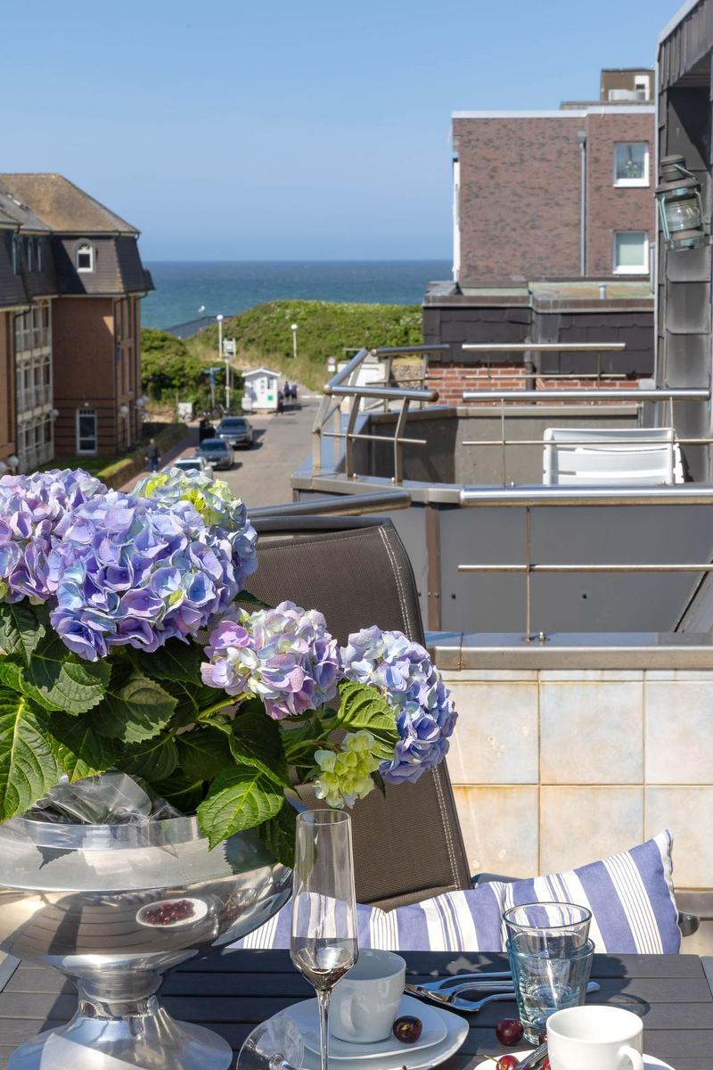 Terrasse mit Blumen, Tisch und Meerblick