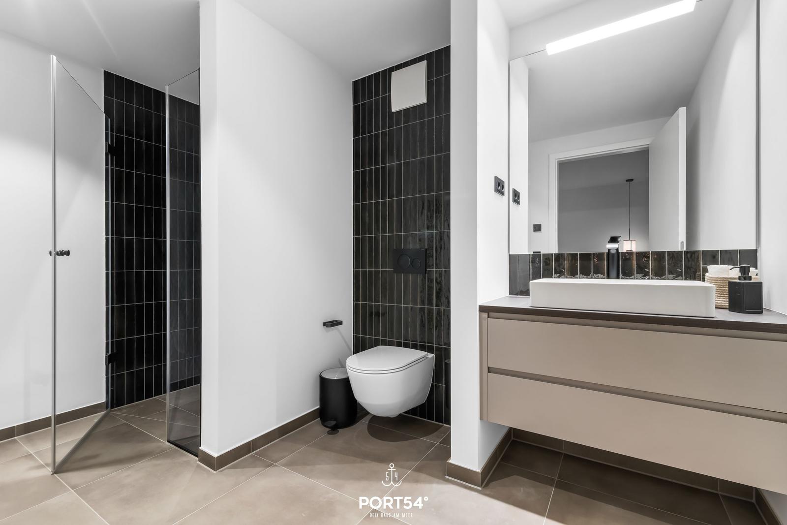 Moderne Badezimmer mit Dusche, Toilette und Waschbecken.