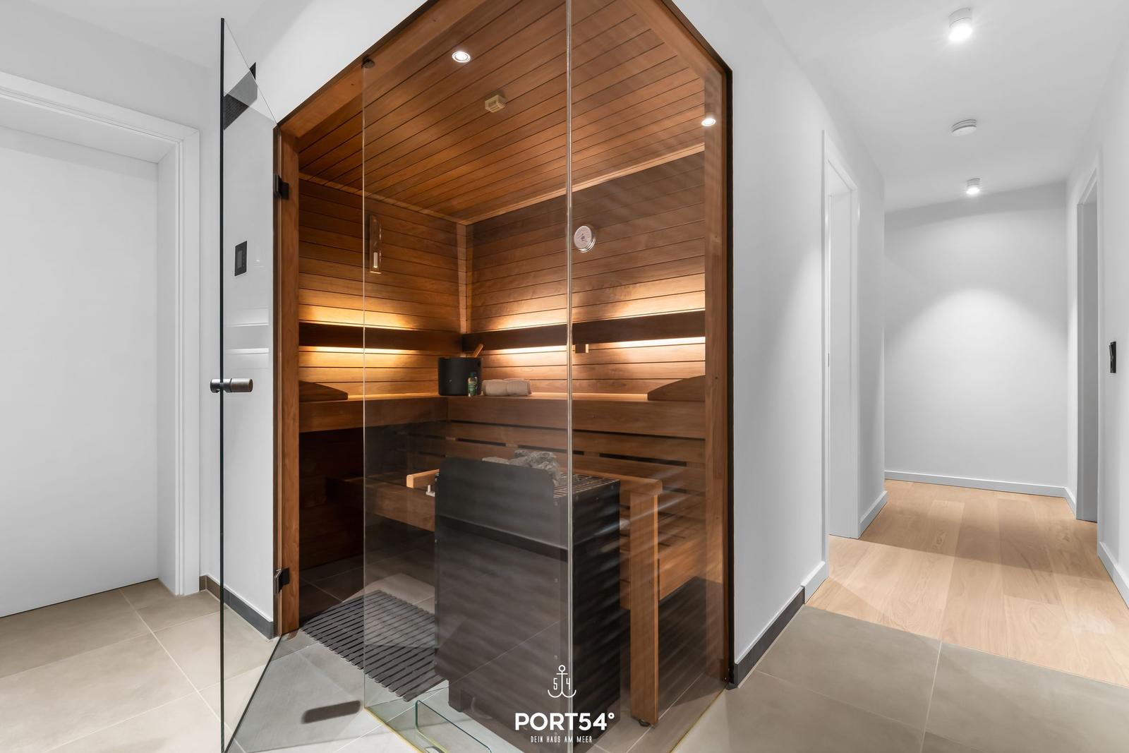 Sauna mit Holzwand und Glasfront in moderner Umgebung