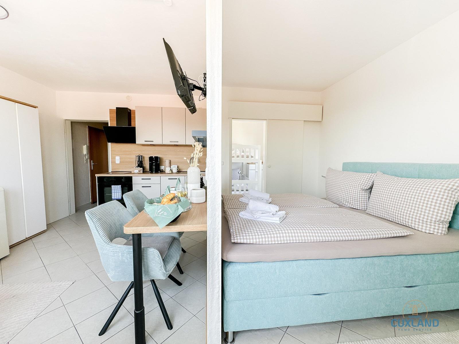 Schlafzimmer mit Bett und Küchenbereich mit Esstisch