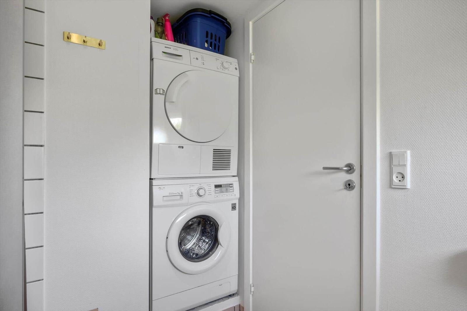 Dryer and washing machine in a room with door and socket