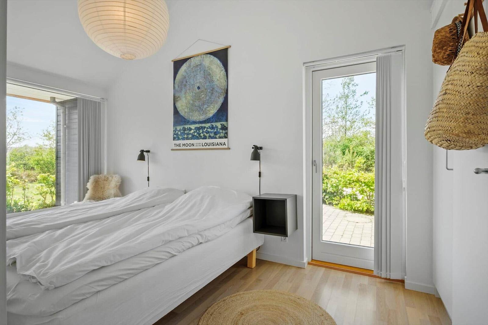 Bedroom with bed, window, and door to terrace.