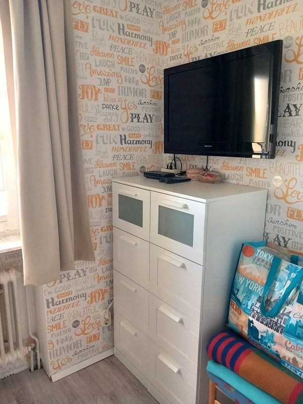 Schrank mit Fernseher und Wand mit Schriftzügen
