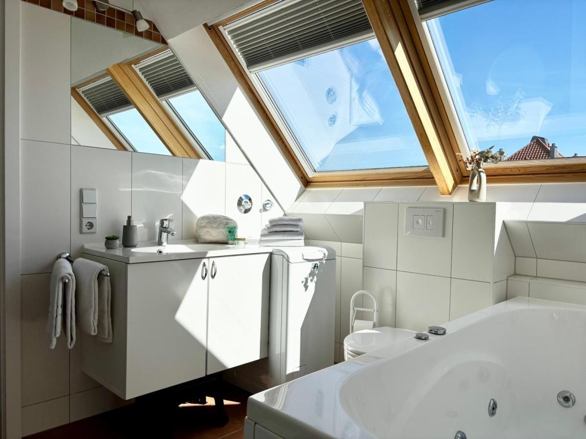 Badezimmer mit Dachfenster, Badewanne und Waschbecken.