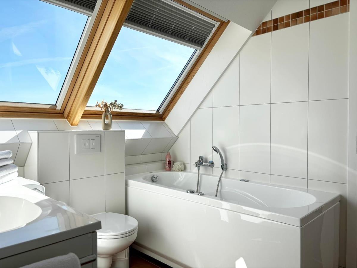 Badezimmer mit Dachfenster, Badewanne und Toilette