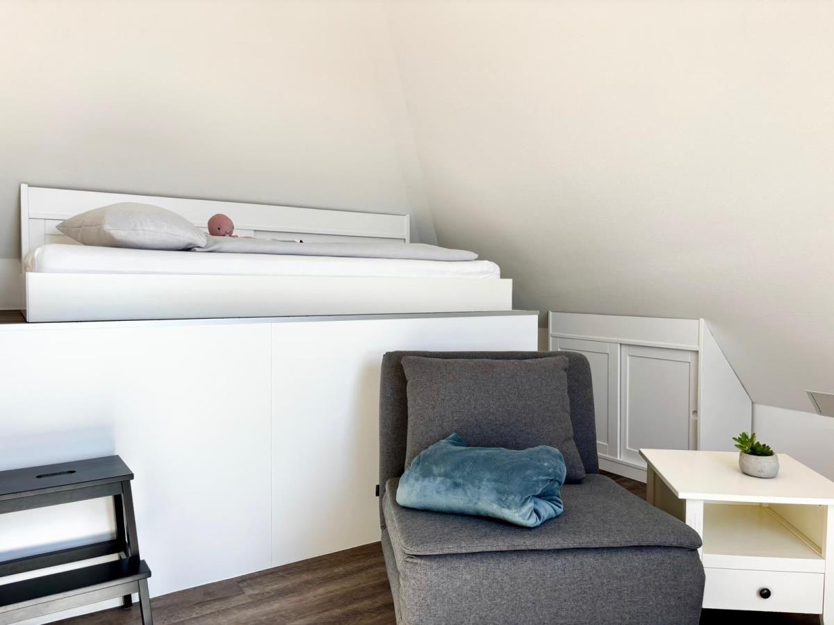 Schlafzimmer mit Hochbett, Sessel und Nachttisch
