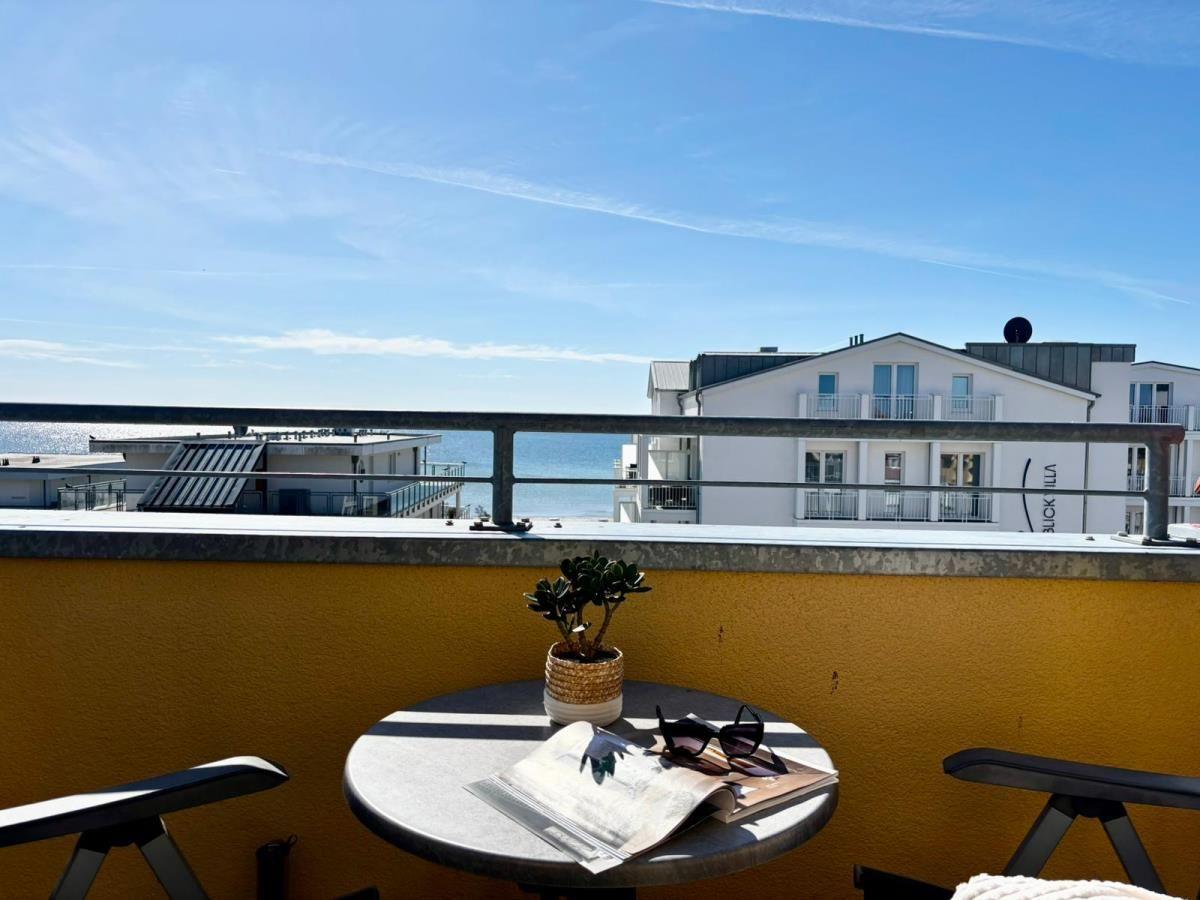 Terrasse mit Tisch, Stuhl und Blick auf das Meer und Gebäude.