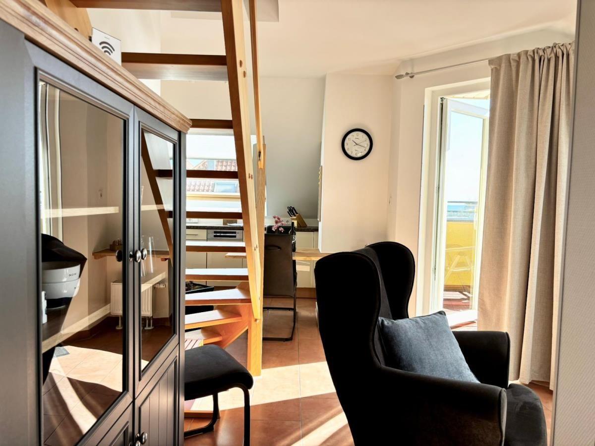 Wohnraum mit Sitzgelegenheit, Glasvitrine und Treppe zur oberen Etage.