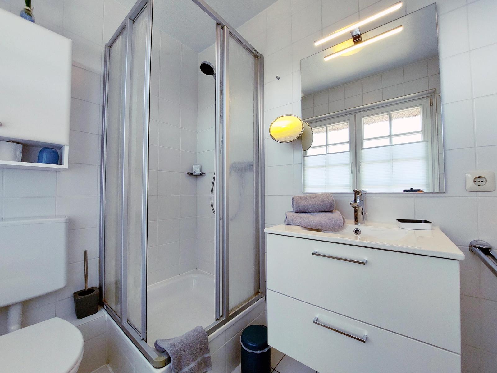 Helles Duschbad mit Badschrank und Föhn