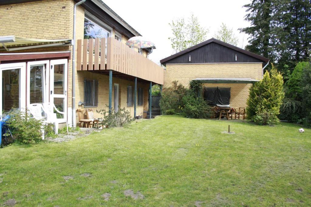 Garten mit überdachter Sitzecke und Balkon der Ferienwohnung