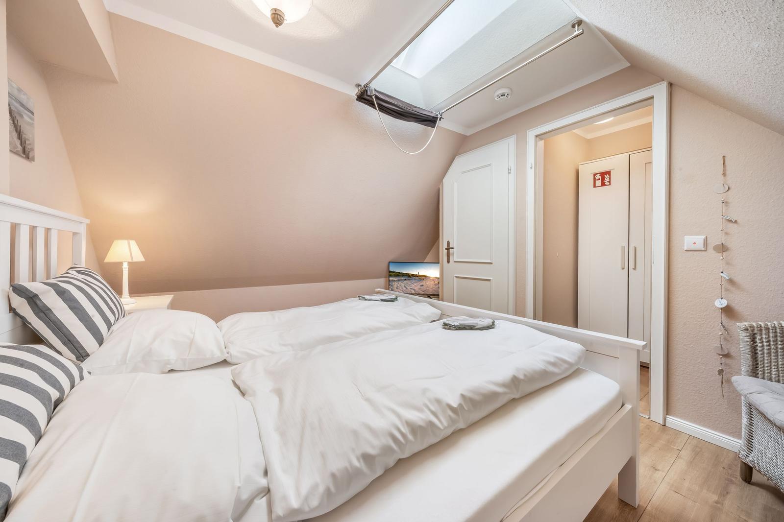 Bedroom with double bed, window, and door to bathroom.