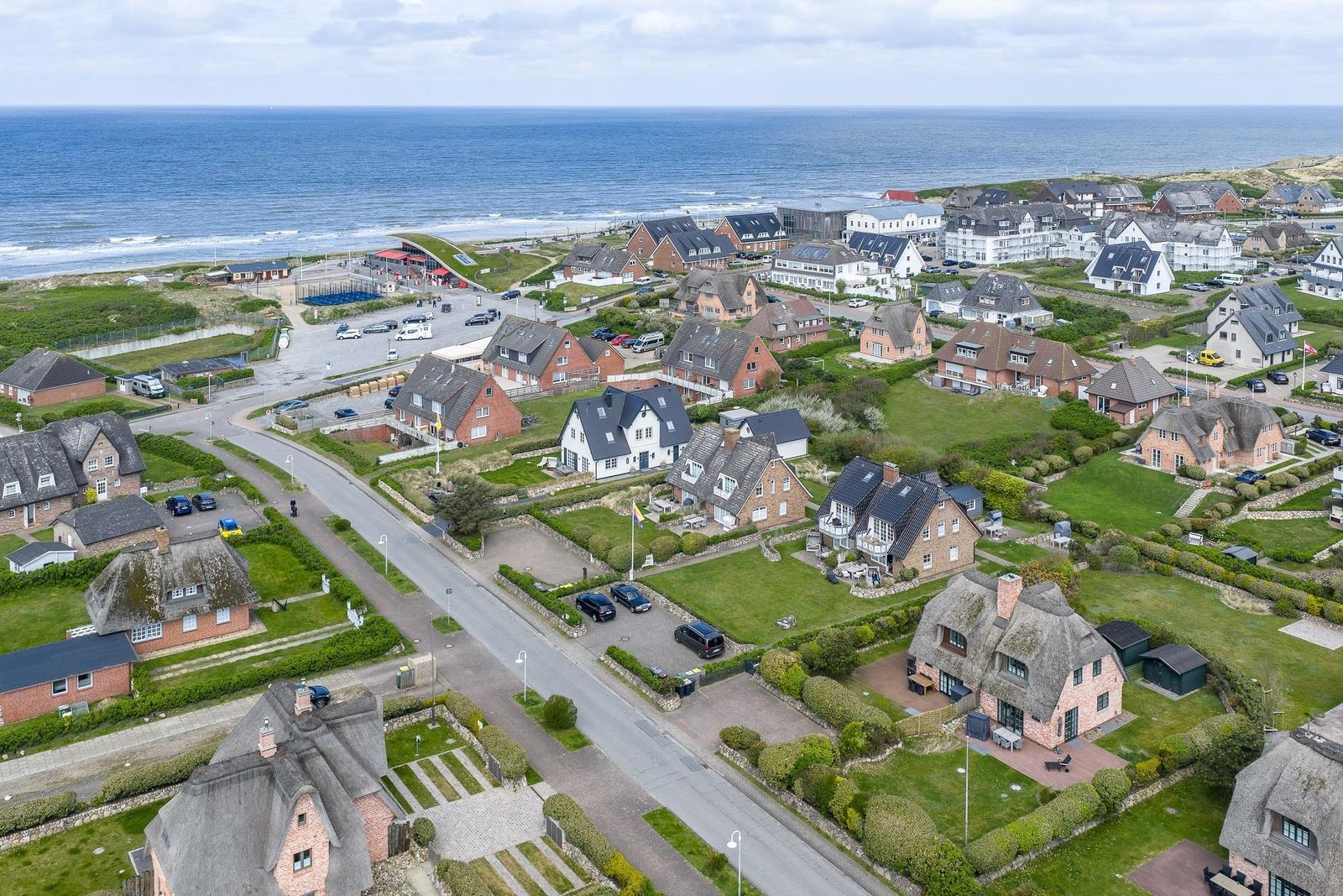 Dorf mit Häusern und Strand im Hintergrund