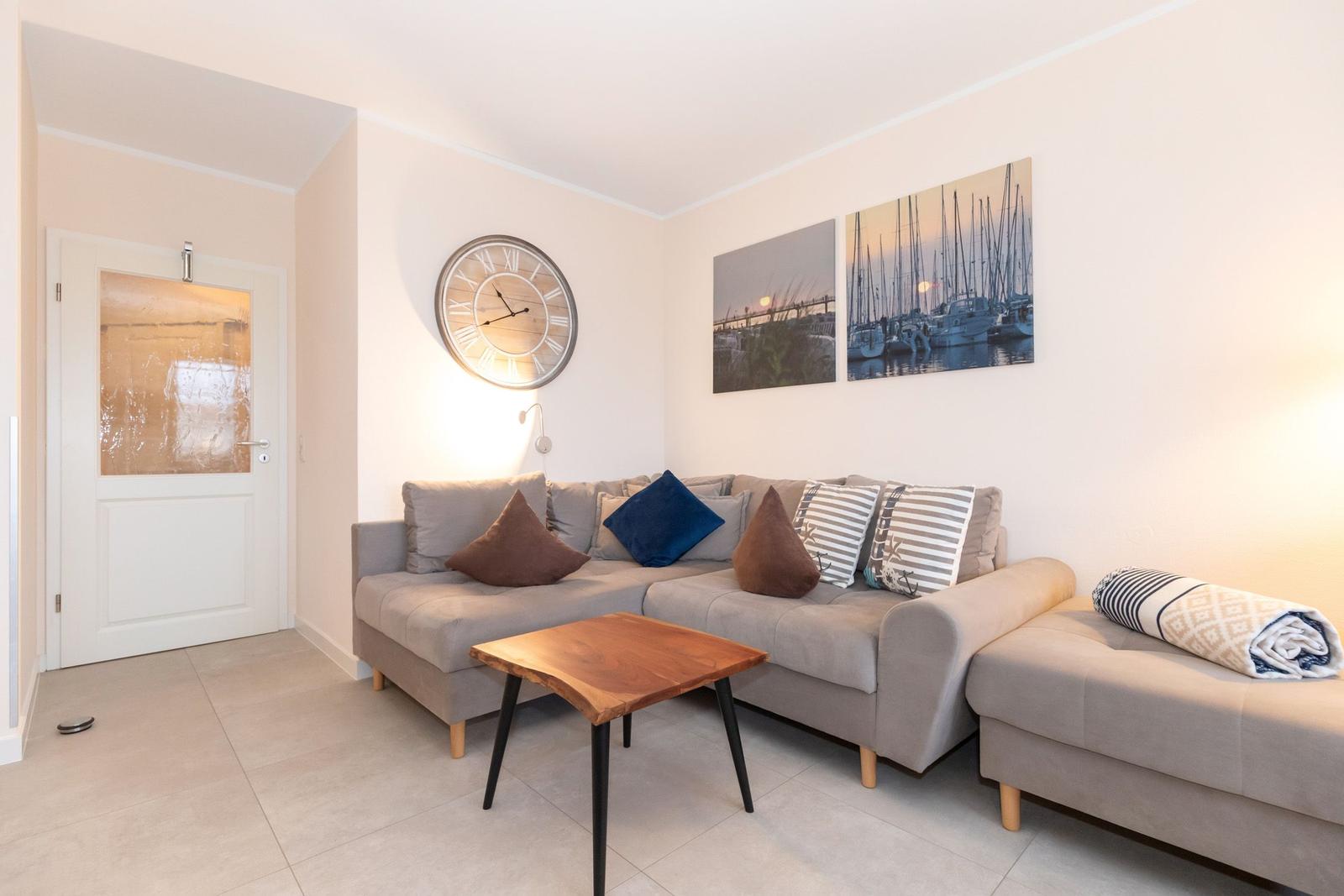 Wohnzimmer mit Sofa, Tisch und Wandbildern