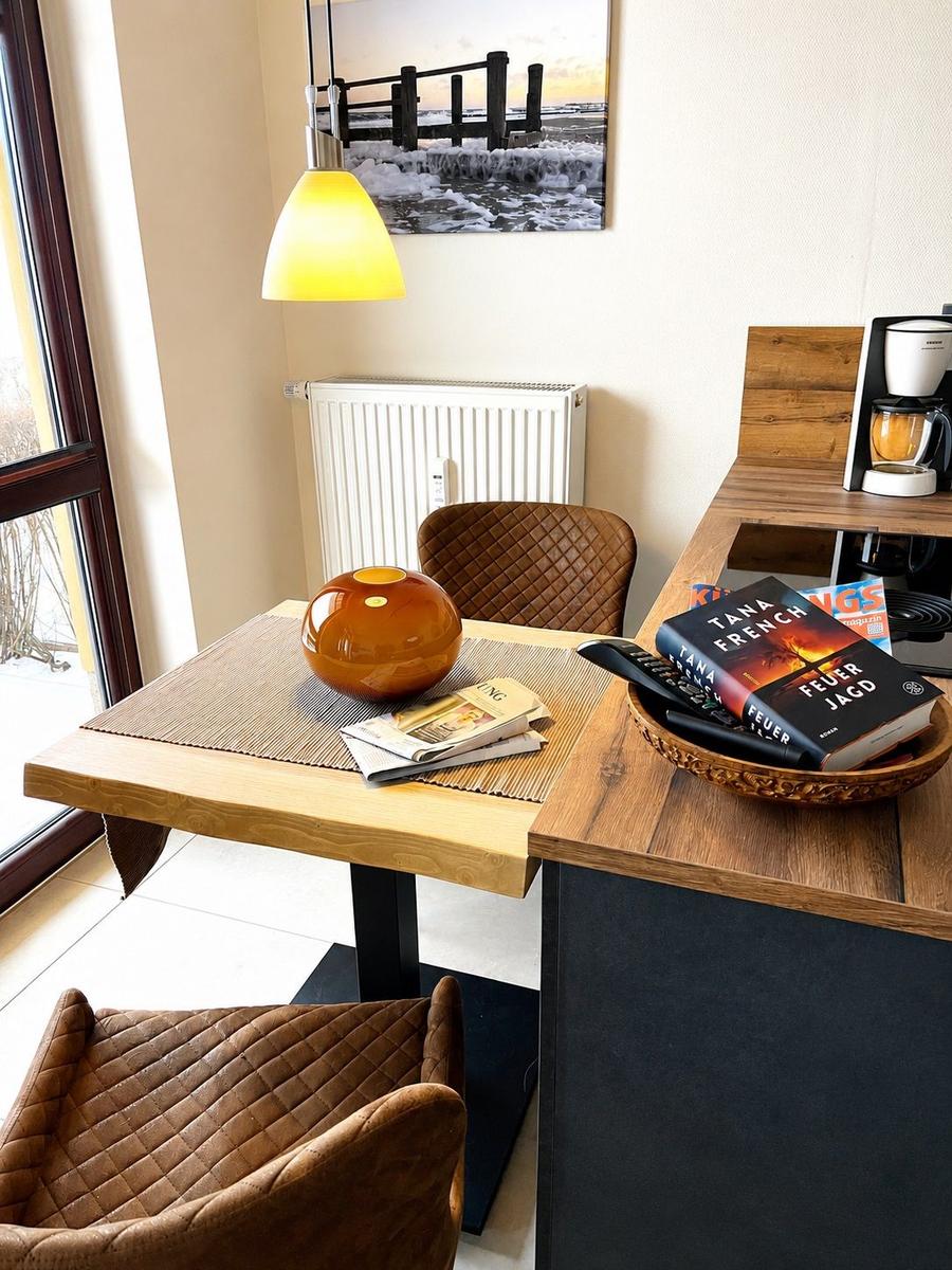Esstisch mit zwei Stühlen, Kaffeemaschine und Wandbild an der Wand.