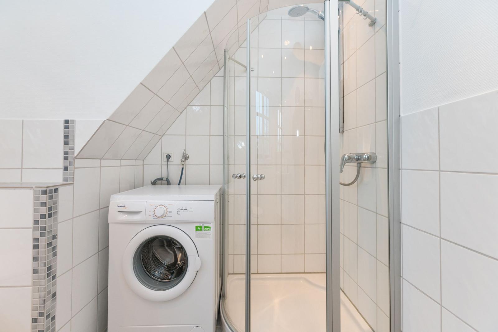 Badezimmer mit Dusche und Waschmaschine unter Dachschrägen