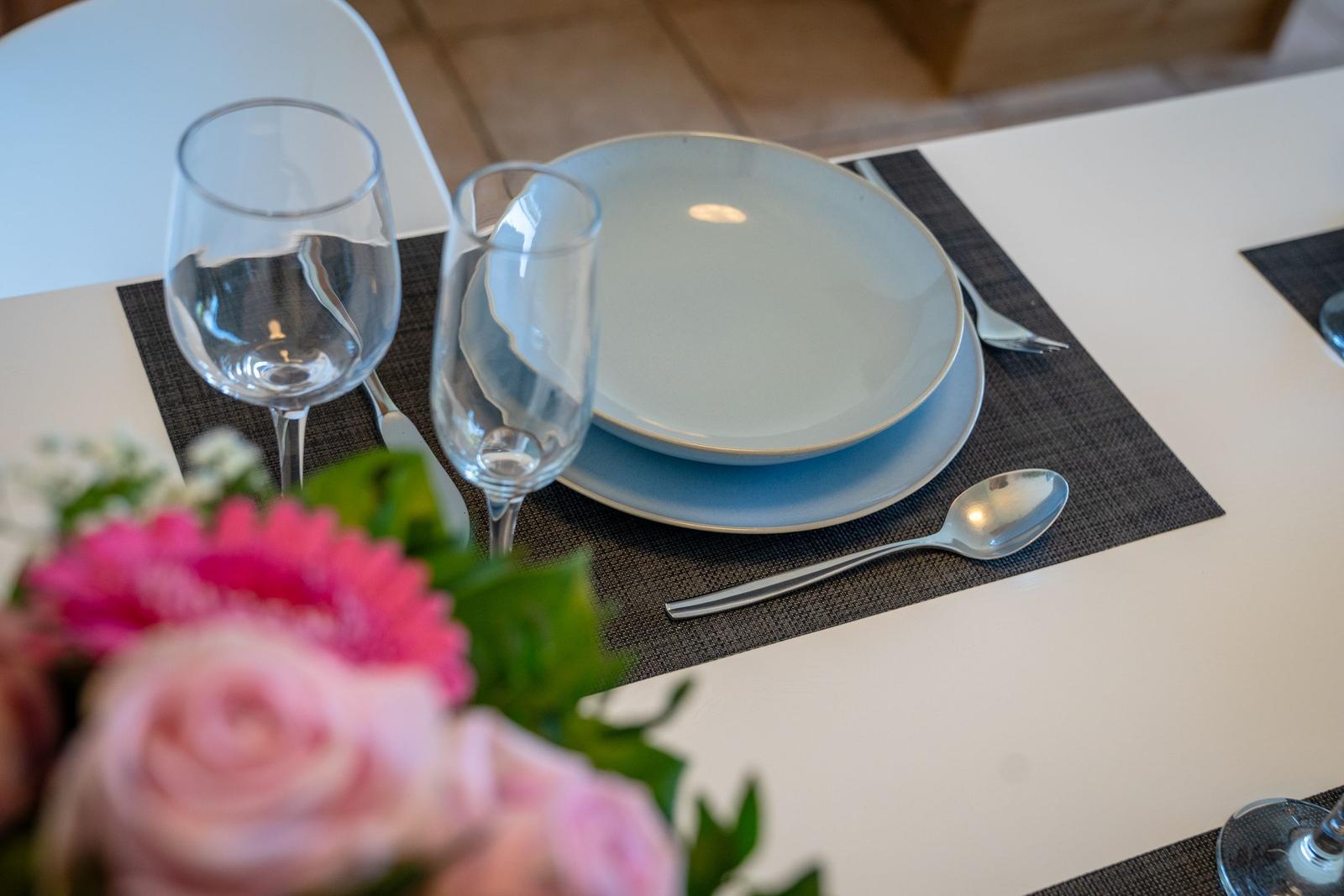 Table set with plates, glasses, and cutlery on placemat.