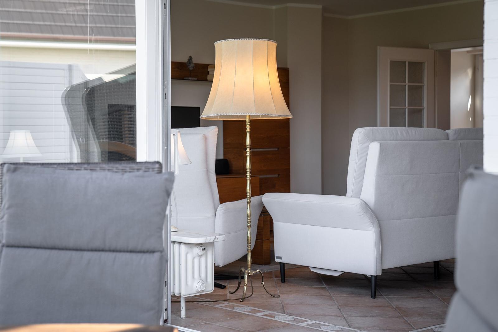 A living room with gray chairs, a floor lamp, and a wooden cabinet.