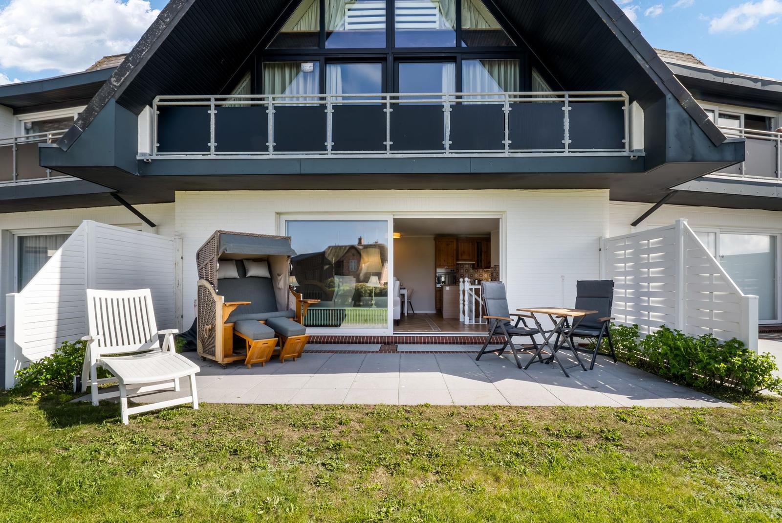 Terrace with garden, lounge, and table. View into kitchen. Two-story with balcony.