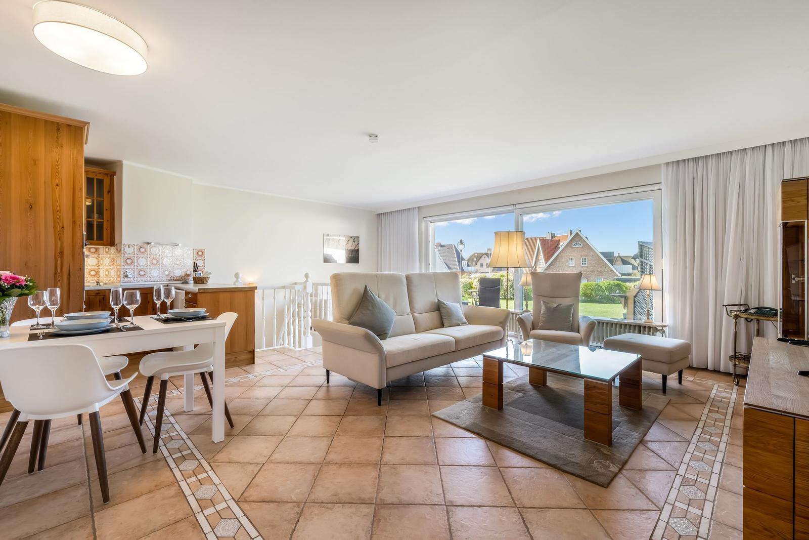 Living and dining area with sofa, table, and view of the surroundings.